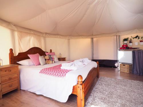 埃姆斯沃思老乳牛场酒店的帐篷内一间卧室,配有一张床