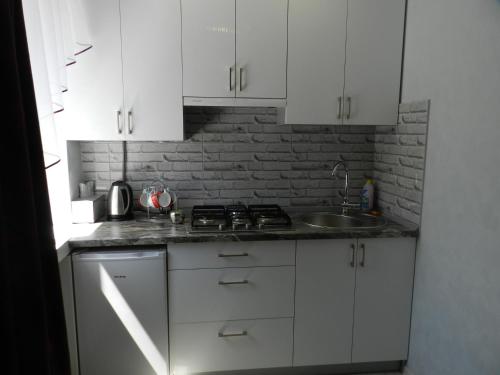 切尔尼戈夫Apartment on Mstyslavs'ka的厨房配有白色橱柜和水槽