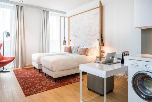 柏林柏林辉盛凯贝丽酒店式服务公寓的酒店客房配有一张床和一台洗衣机