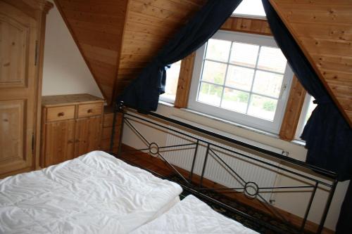 博尔滕哈根Zur alten Schmiede I (Mitte)的一间卧室设有一张床和一个窗口