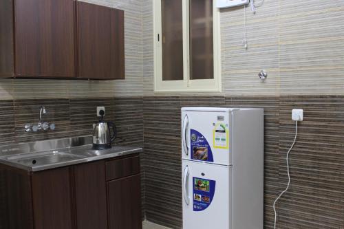 艾卜哈Rayanat Abha Aparthotel的厨房配有白色冰箱和水槽
