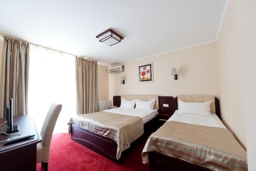 艾福雷诺德北埃福列蒙迪尔酒店的酒店客房设有两张床、一张桌子和一台电脑。