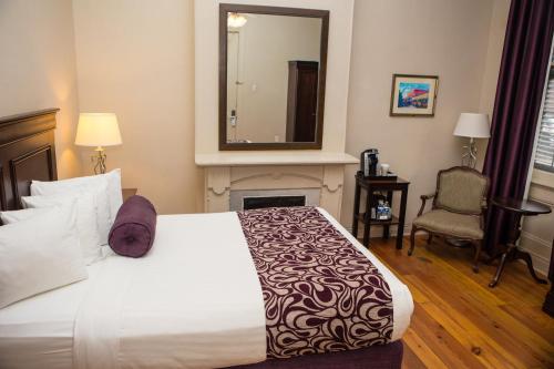 新奥尔良法国区圣彼得旅馆的一间卧室配有一张带壁炉和镜子的床