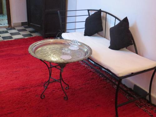 丹吉尔阿鲁斯卡梅尔摩洛哥传统庭院旅馆的一张咖啡桌,坐在床边