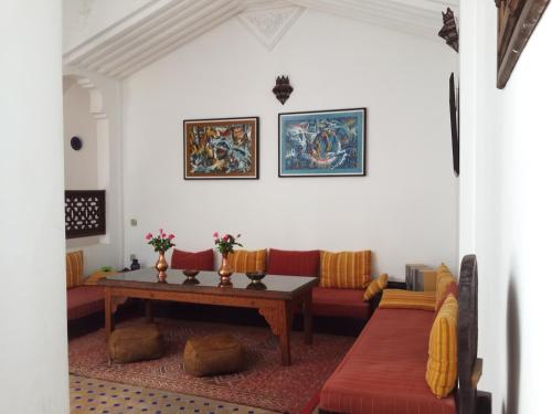 丹吉尔阿鲁斯卡梅尔摩洛哥传统庭院旅馆的客厅配有桌子和沙发