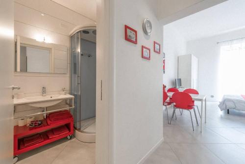 巴里A due passi dal centro - Bari Policlinico的白色浴室设有水槽和红色椅子