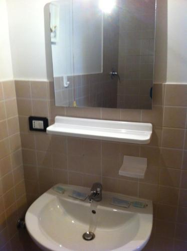 热那亚潘森酒店的浴室设有白色水槽和镜子