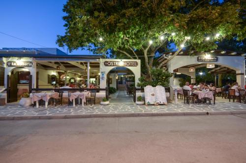 阿吉奥斯普罗科皮奥斯Ostria Hotel的人行道上设有桌椅的餐厅