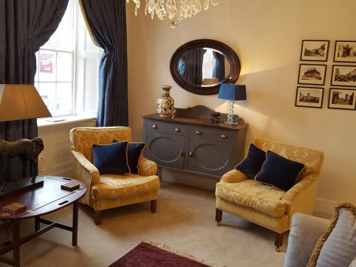 科尔福德Pomegranate的客厅配有两把椅子和镜子