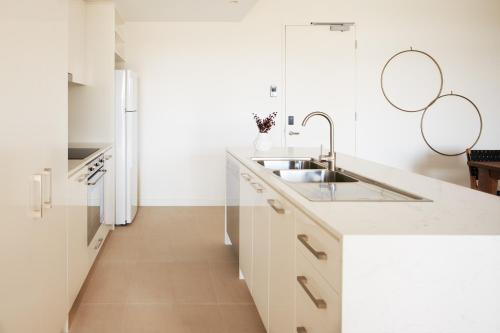弗里曼特Nautica Residences Fremantle的厨房配有白色橱柜和水槽