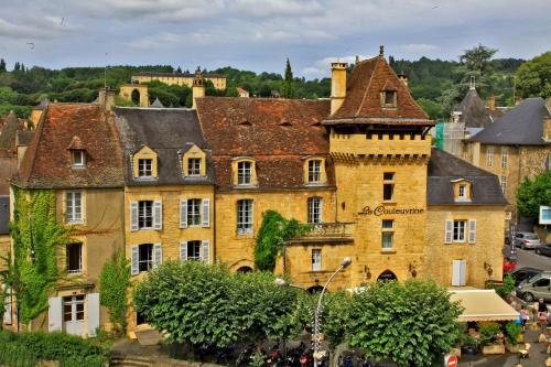 萨尔拉拉卡内达Hôtel La Couleuvrine Sarlat Centre Ville的一座城市中带有塔的古老建筑