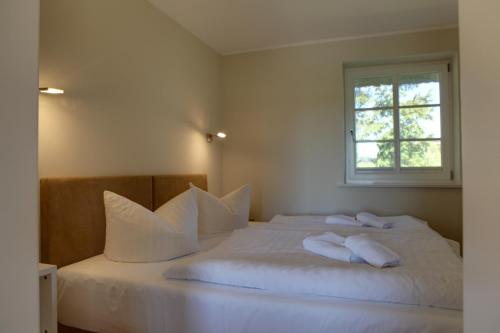 洛默Haus Sonnenblume的卧室配有带枕头的白色床和窗户。