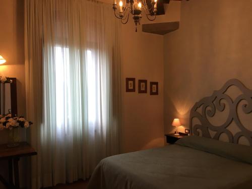 科尔托纳阿格利萨洛托酒店的一间卧室配有床和带窗帘的窗户