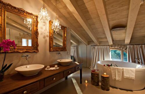LladursLa Vella Farga Hotel的一间带两个盥洗盆和大浴缸的浴室