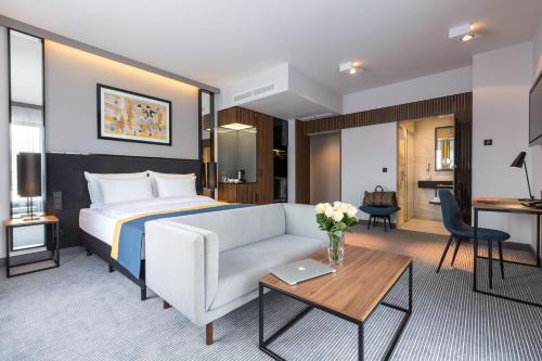 克拉科夫阿斯科特大酒店的酒店客房配有床、沙发和桌子。