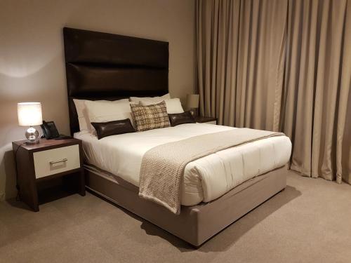 巴利托Zimbali Suites 304的一间卧室配有一张大床和黑色床头板