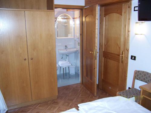 拉比Alpen Hotel Rabbi的一间带水槽、镜子和卫生间的浴室