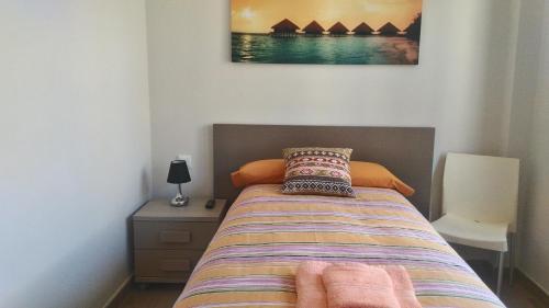 Lorca塞克玛度假屋的一间卧室配有床、床头柜和图片