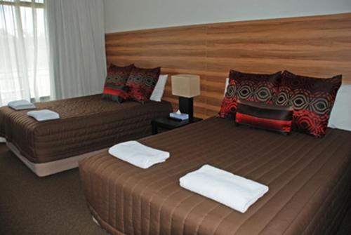 堪培拉红雪松汽车旅馆的酒店客房带两张床和一个大床头板