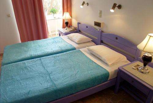 卡拉马基多琳公寓的一间卧室配有蓝色的床和两个枕头