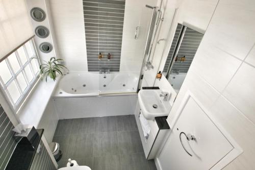 奥斯威斯潘益典雅芙蓉玉女乡村酒店的白色的浴室设有浴缸和水槽。