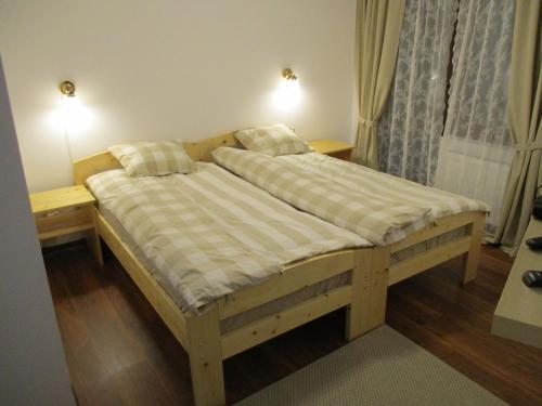 Poiana GaldeiCabana Poiana Galdei的一张木床,房间有两个床头柜