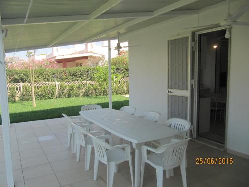 蓬塔布拉切托villetta al mare punta braccetto的庭院里的白色桌椅