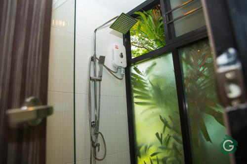 武里南武里南府格林酒店的靠窗的浴室里的一个淋浴