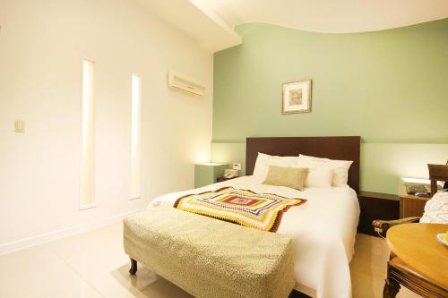 木浦市莎曼酒店的一间卧室配有一张大床和一把椅子