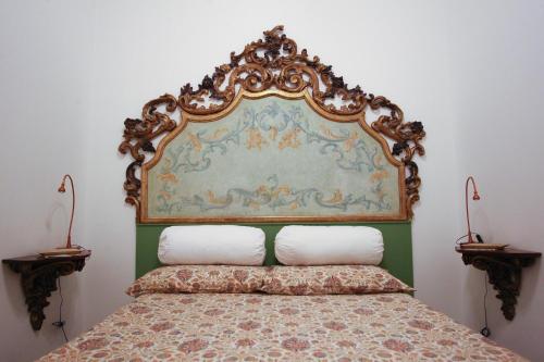 米兰拉皮斯公寓的卧室内一张带华丽床头板的床