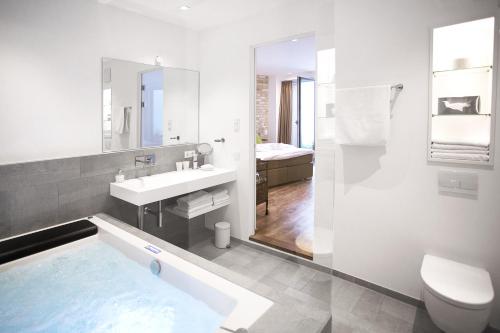 科隆科隆一楼2号酒店的带浴缸、盥洗盆和卫生间的浴室