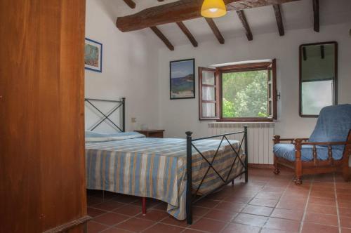 斯卡尔利诺Podere i Giganti的卧室配有床、椅子和窗户。