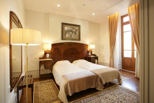 科英布拉壹贝爱瑞科酒店的一间卧室配有床、灯和窗户