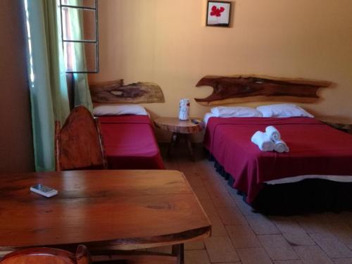 伊瓜苏港皇家伊瓜苏旅馆的酒店客房设有两张床、一张桌子和一张桌子。