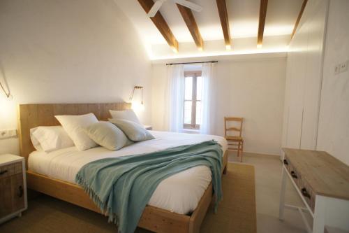 桑特略伦斯斯德斯卡尔达萨尔Ca Na Nina的一间卧室配有一张大床和木制床头板
