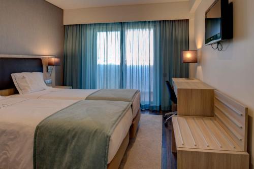 里斯本贵宾酒店的酒店客房设有两张床和电视。