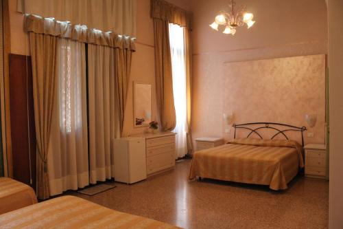 威尼斯Palazzo Lion Morosini - Check in presso Locanda Ai Santi Apostoli的酒店客房,设有两张床和镜子