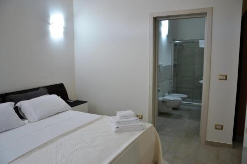 切萨雷奥港Palazzo Greco Case Vacanze的一间卧室配有一张床,浴室设有卫生间