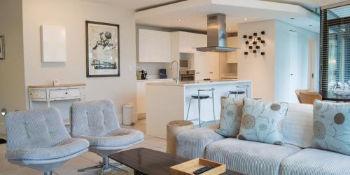 开普敦格兰公寓的带沙发和椅子的客厅以及厨房。