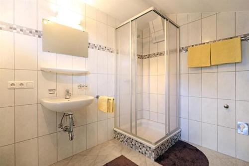 格英Lanzenbauernhof的一间带玻璃淋浴和水槽的浴室