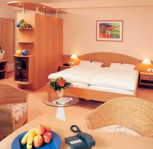 弗洛托森克尔特艾克莫尔兰德酒店的一间卧室配有一张床和一张带水果的桌子