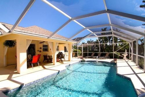 珊瑚角Villa Joella的一座房子上方的带遮阳伞的游泳池