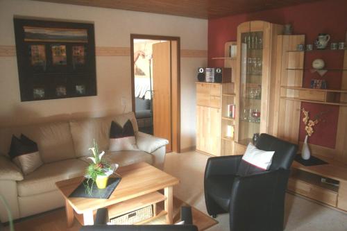 施莱登Ferienwohnung-Geschwind的客厅配有沙发和桌椅
