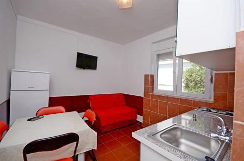 格拉达茨Apartments Josko的厨房配有红色的沙发和红色的椅子