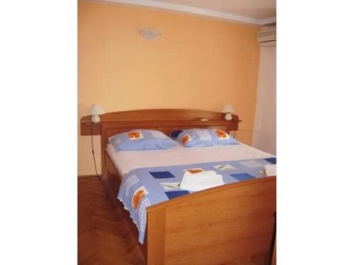 斯拉诺House Antun的一间卧室配有一张带蓝色枕头的木床。