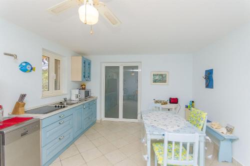 尼亚卢卡Apartment Blue的厨房配有蓝色橱柜、桌子和用餐室。