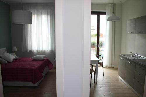 普拉托埃米利奥公寓的一间卧室配有一张床,厨房配有水槽
