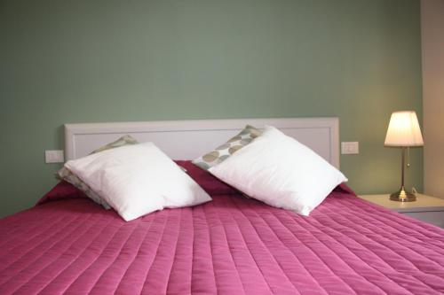 普拉托埃米利奥公寓的卧室配有粉红色的床和2个枕头