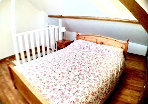 里尔卢米埃住宿加早餐旅馆的一张木床,位于一个配有婴儿床的房间