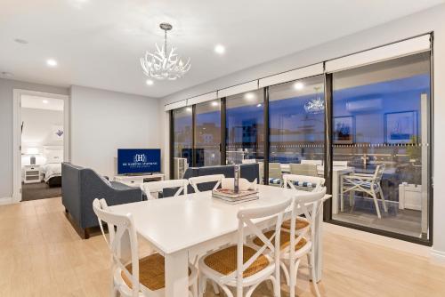 墨尔本The Hamptons Apartments - Port Melbourne的白色的用餐室配有白色的桌椅